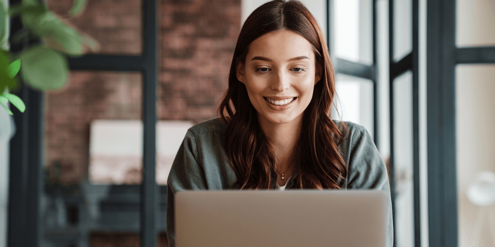 Smiling person looking at a laptop