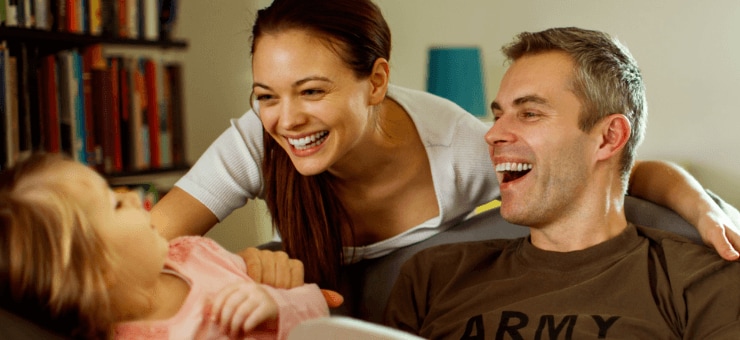 Mother and military father smiling with their child