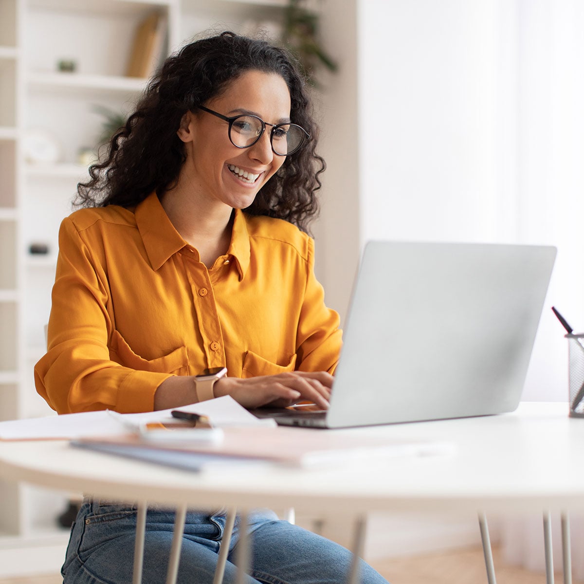 Happy Middle Eastern Businesswoman Using Laptop Sitting At Workplace