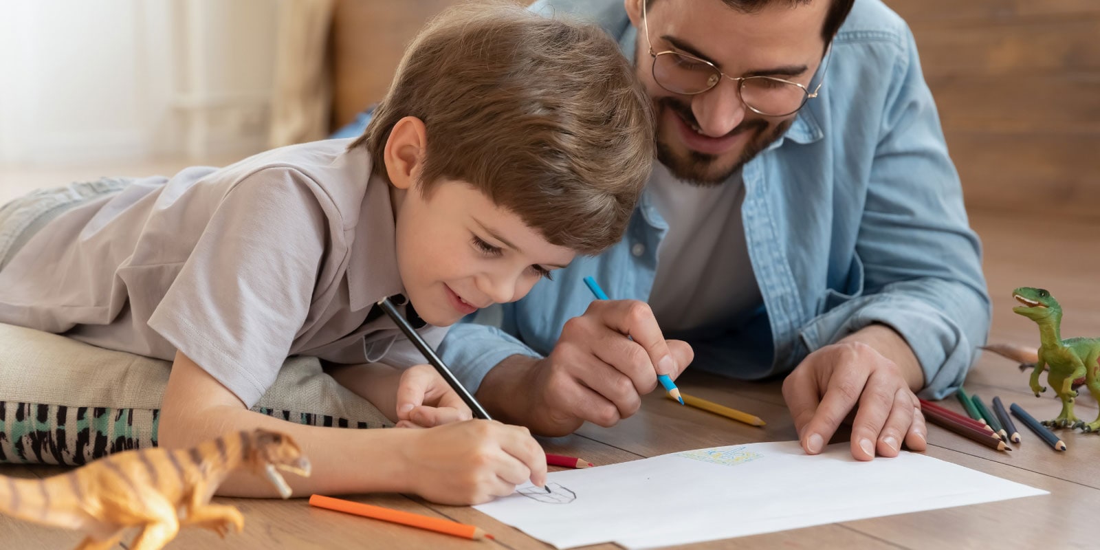 Father and son drawing on the floor.