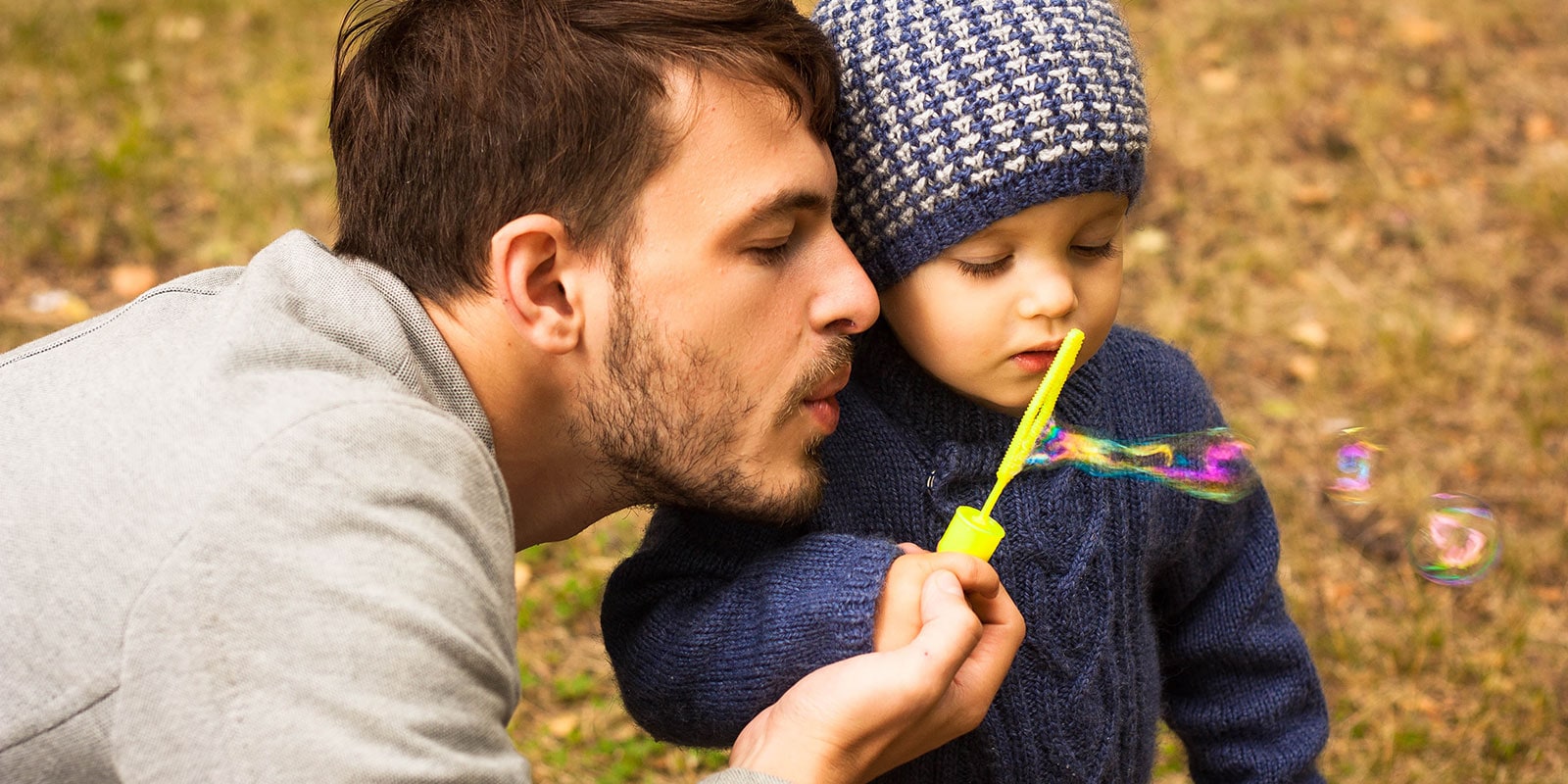 Father and son blowing bubbles together.